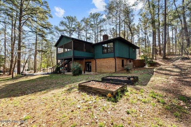105 Tartan Trl, Southern Pines, NC 28387 - back of house with a sunroom, a chimney, brick siding, and stairs