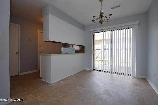 110 Concord Dr Unit C, Greenville, NC 27834 - unfurnished dining area with a chandelier, baseboards, and stone finish floors