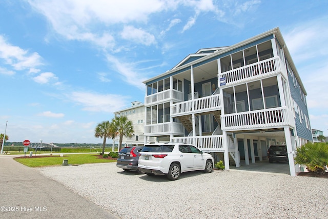 405 27th St Unit A, Sunset Beach, NC 28468 - view of building exterior featuring a carport and gravel driveway
