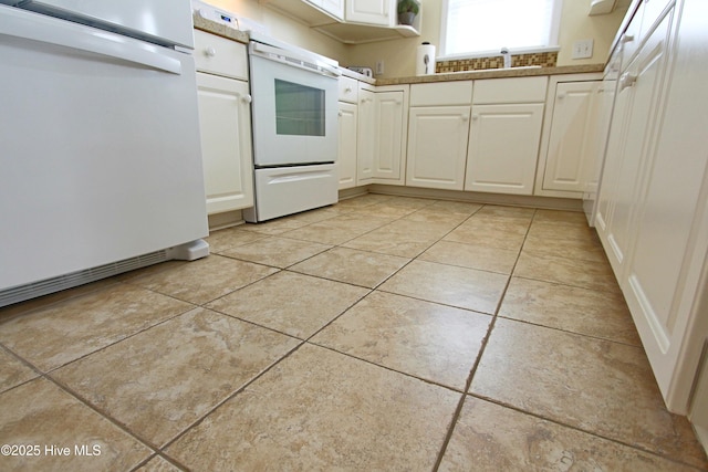 405 27th St Unit A, Sunset Beach, NC 28468 - kitchen featuring white appliances, light tile patterned floors, white cabinetry, and a sink