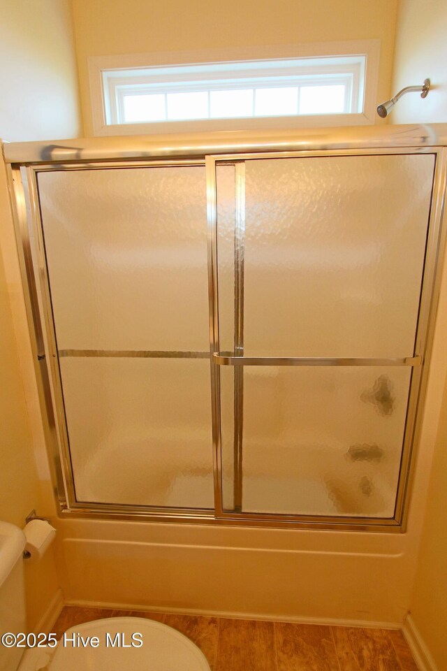 405 27th St Unit A, Sunset Beach, NC 28468 - bathroom with toilet, bath / shower combo with glass door, and baseboards