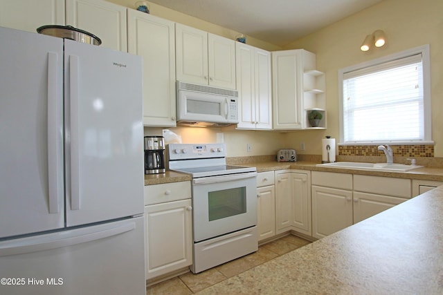 405 27th St Unit A, Sunset Beach, NC 28468 - kitchen featuring white appliances, a sink, light tile patterned flooring, white cabinetry, and light countertops