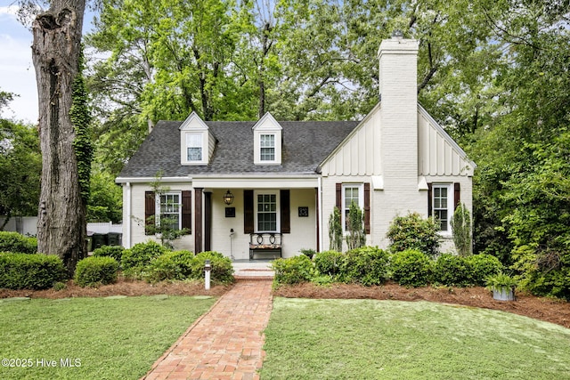1305 Kenan St NW, Wilson, NC 27893 - view of front facade with covered porch, a chimney, a front lawn, and brick siding