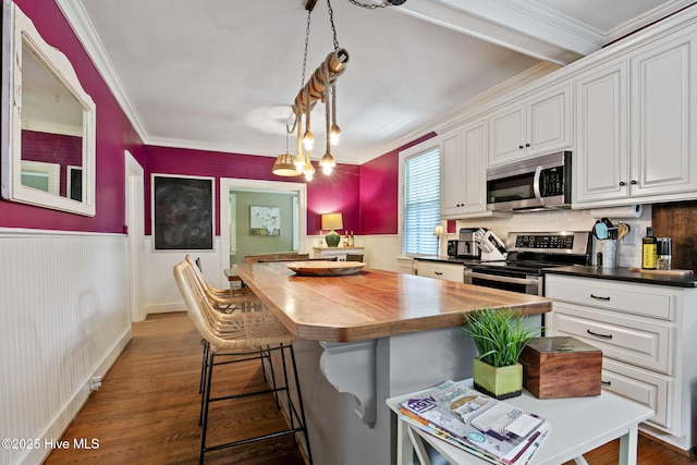 1305 Kenan St NW, Wilson, NC 27893 - kitchen featuring stainless steel appliances, butcher block counters, white cabinetry, dark wood-type flooring, and crown molding