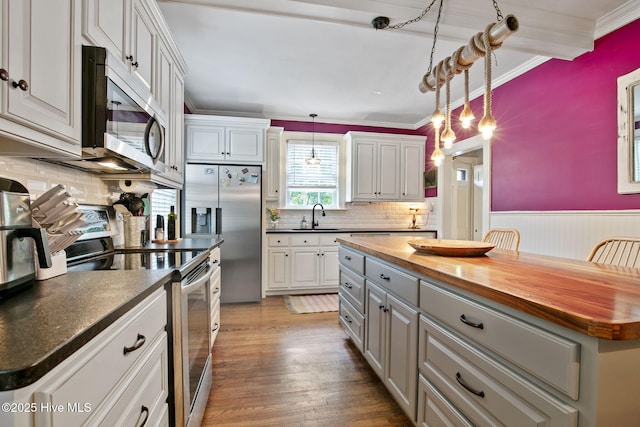 1305 Kenan St NW, Wilson, NC 27893 - kitchen featuring stainless steel appliances, wood counters, a sink, ornamental molding, and decorative backsplash