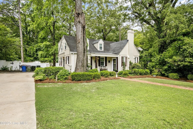 1305 Kenan St NW, Wilson, NC 27893 - view of front of house with concrete driveway, a chimney, covered porch, and a shingled roof