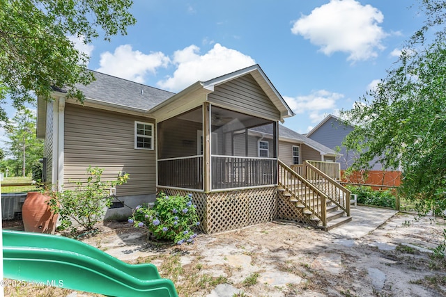 1711 Reidsville Rd, Southport, NC 28461 - rear view of house with a sunroom, roof with shingles, and a playground