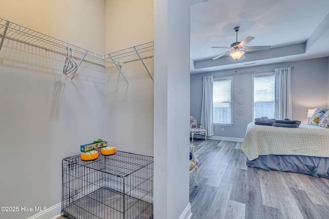 576 Steele Loop, Wilmington, NC 28411 - bedroom with wood finished floors, baseboards, a tray ceiling, and a ceiling fan