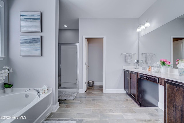 576 Steele Loop, Wilmington, NC 28411 - full bathroom featuring double vanity, a shower stall, a bath, baseboards, and wood finished floors