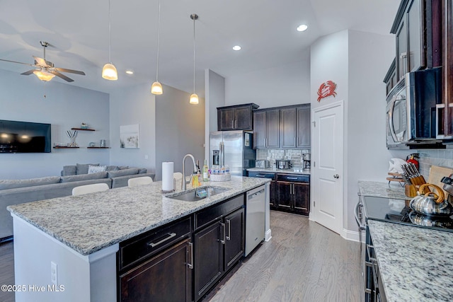576 Steele Loop, Wilmington, NC 28411 - kitchen featuring appliances with stainless steel finishes, a sink, decorative backsplash, wood finished floors, and open floor plan