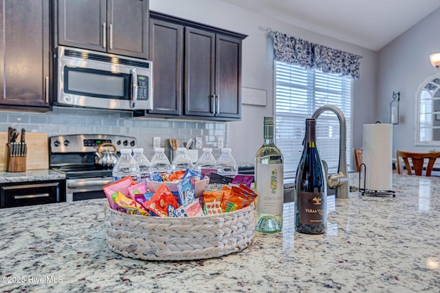 576 Steele Loop, Wilmington, NC 28411 - kitchen with appliances with stainless steel finishes, light stone countertops, decorative backsplash, and dark brown cabinets