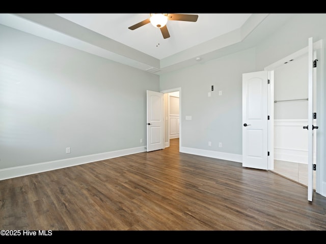 7024 Bonaventure St SW, Ocean Isle Beach, NC 28469 - unfurnished bedroom with dark wood-type flooring, baseboards, and ceiling fan