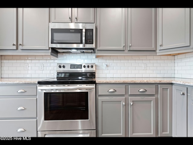 7024 Bonaventure St SW, Ocean Isle Beach, NC 28469 - kitchen featuring stainless steel appliances, tasteful backsplash, light stone counters, and gray cabinets