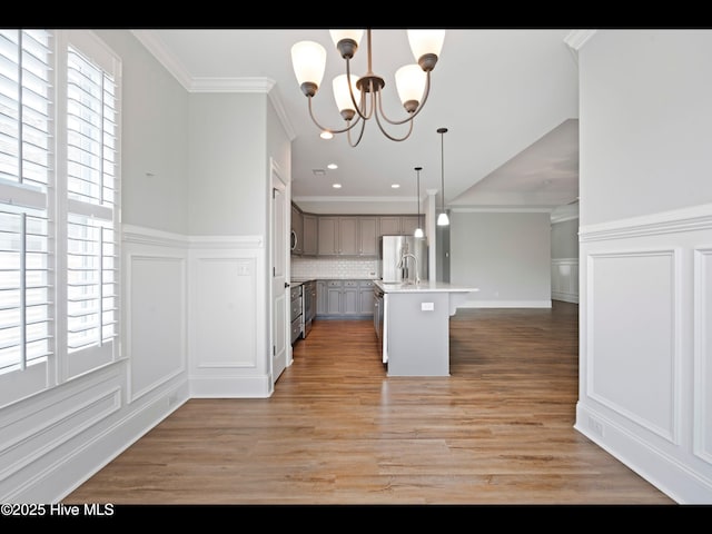 7024 Bonaventure St SW, Ocean Isle Beach, NC 28469 - kitchen with freestanding refrigerator, a chandelier, a decorative wall, light countertops, and open floor plan
