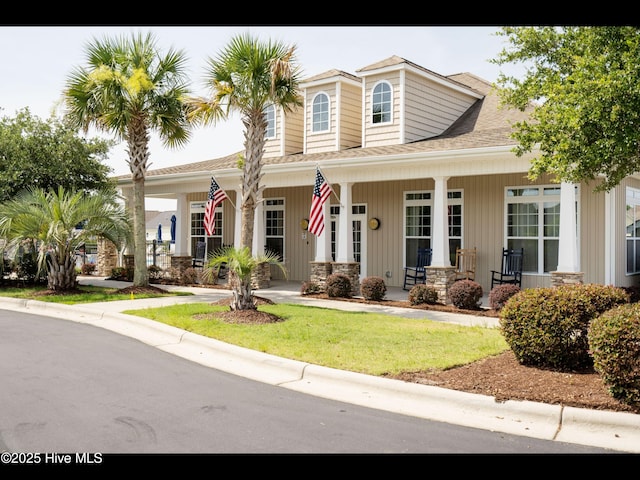 7024 Bonaventure St SW, Ocean Isle Beach, NC 28469 - view of front of house with a porch, a front yard, and roof with shingles