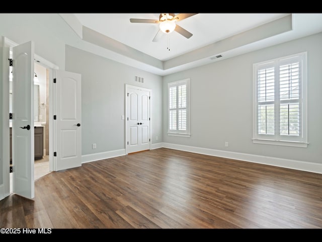 7024 Bonaventure St SW, Ocean Isle Beach, NC 28469 - unfurnished bedroom featuring wood finished floors, baseboards, and a raised ceiling