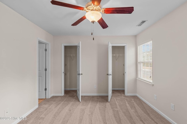 505 Oyster Rock Ln, Sneads Ferry, NC 28460 - unfurnished bedroom featuring two closets, light carpet, baseboards, and ceiling fan