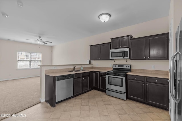 505 Oyster Rock Ln, Sneads Ferry, NC 28460 - kitchen featuring stainless steel appliances, a sink, a peninsula, a ceiling fan, and light countertops