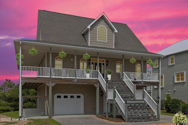 108 Kiawa Way, Atlantic Beach, NC 28512 - coastal inspired home with covered porch, an attached garage, roof with shingles, concrete driveway, and stairs