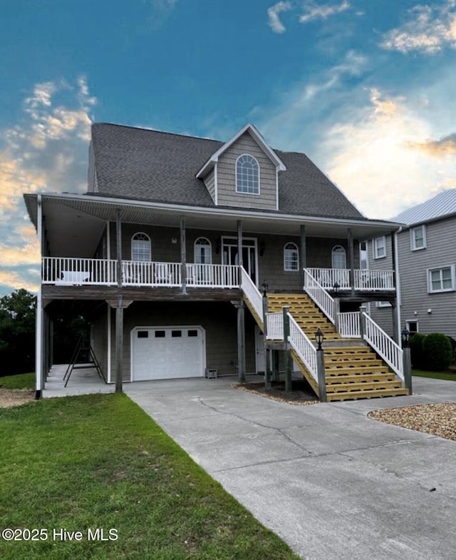 108 Kiawa Way, Atlantic Beach, NC 28512 - raised beach house featuring an attached garage, covered porch, stairway, a front lawn, and a shingled roof