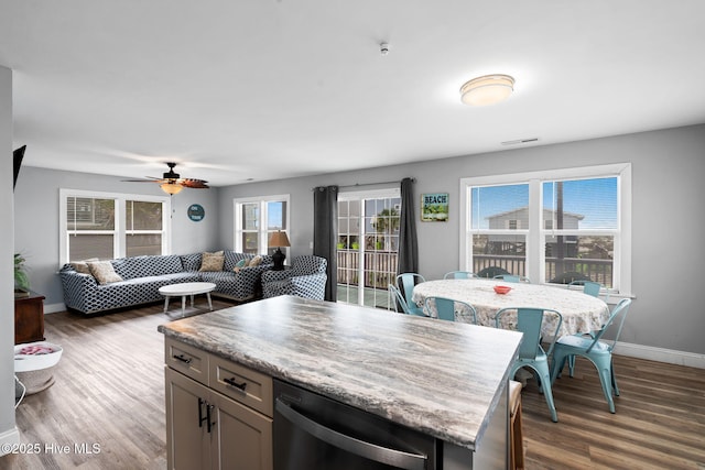 926 E Beach Dr, Oak Island, NC 28465 - kitchen with dark wood-style flooring, stainless steel dishwasher, baseboards, and ceiling fan