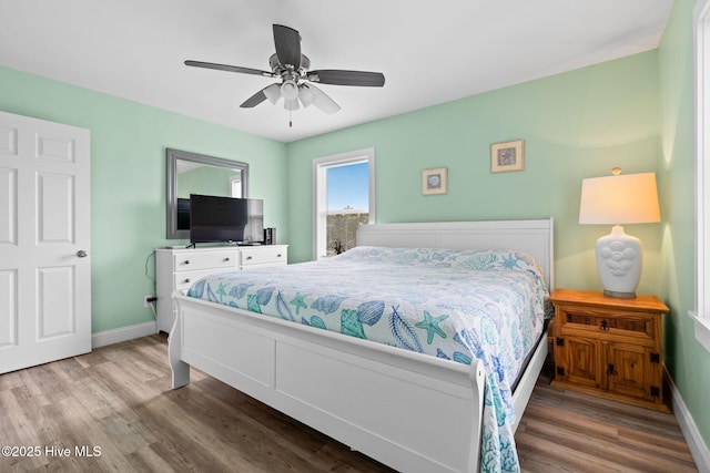 926 E Beach Dr, Oak Island, NC 28465 - bedroom with wood finished floors, baseboards, and a ceiling fan