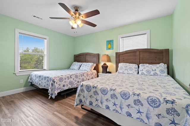 926 E Beach Dr, Oak Island, NC 28465 - bedroom featuring wood finished floors, baseboards, and ceiling fan