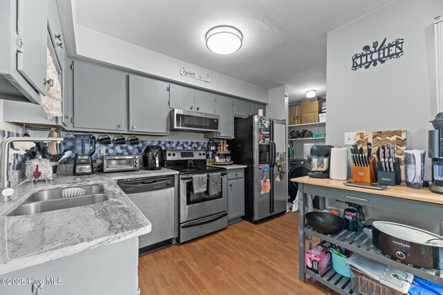 24 Donnell, Havelock, NC 28532 - kitchen with appliances with stainless steel finishes, a sink, gray cabinets, light wood-type flooring, and light stone counters