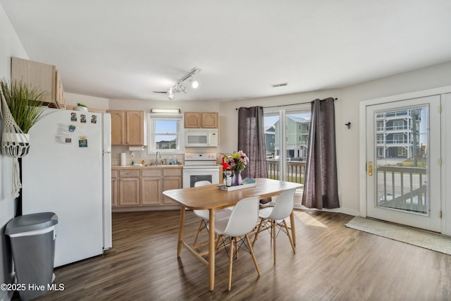 3045 Island Dr, North Topsail Beach, NC 28460 - dining area featuring dark wood finished floors, rail lighting, and baseboards