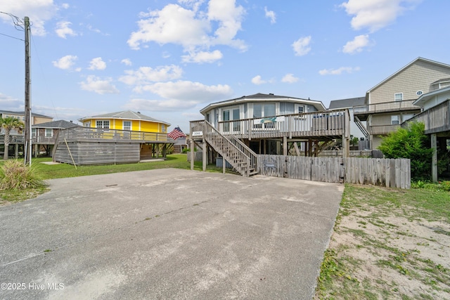 3045 Island Dr, North Topsail Beach, NC 28460 - rear view of house featuring a wooden deck, stairs, a residential view, and driveway
