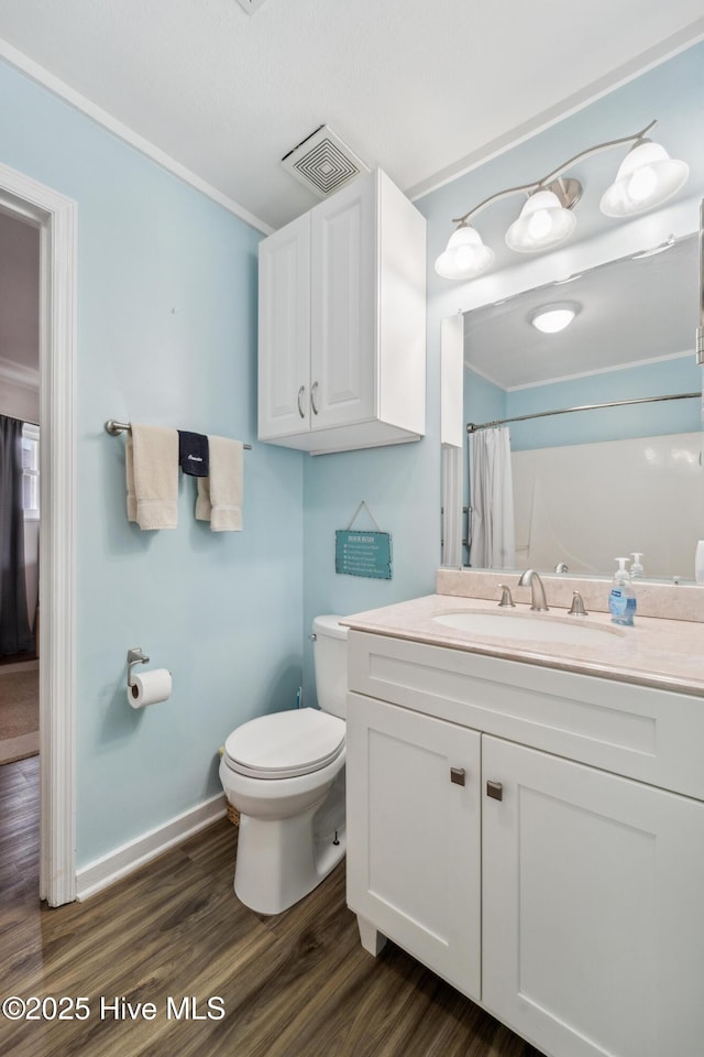 3045 Island Dr, North Topsail Beach, NC 28460 - bathroom featuring toilet, wood finished floors, vanity, a shower with shower curtain, and crown molding