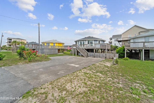 3045 Island Dr, North Topsail Beach, NC 28460 - rear view of property with a deck, a residential view, driveway, stairway, and a yard