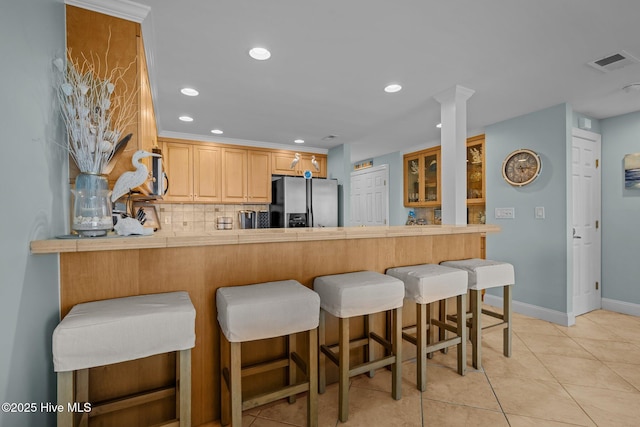 331 Salter Path Rd Unit 211, Pine Knoll Shores, NC 28512 - kitchen with stainless steel refrigerator with ice dispenser, a peninsula, tasteful backsplash, a kitchen bar, and baseboards