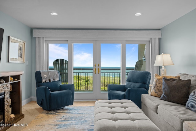 331 Salter Path Rd Unit 211, Pine Knoll Shores, NC 28512 - living area featuring light tile patterned floors, recessed lighting, a water view, a stone fireplace, and baseboards