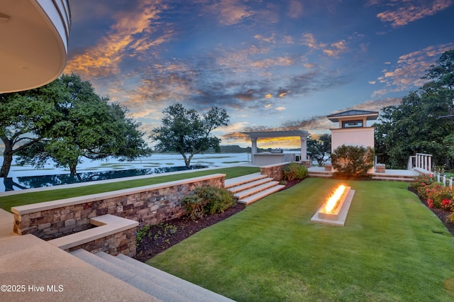 1064 Ocean Ridge Dr, Wilmington, NC 28405 - view of green lawn with a fire pit and a water view