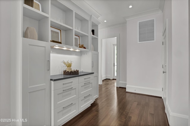 1064 Ocean Ridge Dr, Wilmington, NC 28405 - kitchen with open shelves, dark countertops, dark wood finished floors, crown molding, and baseboards