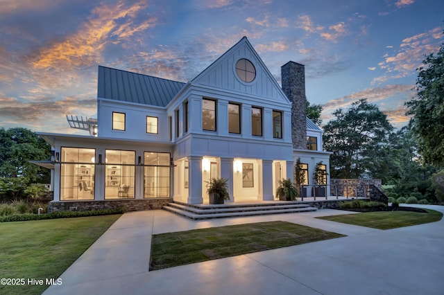 1064 Ocean Ridge Dr, Wilmington, NC 28405 - view of front of home featuring a standing seam roof, a chimney, metal roof, and a yard