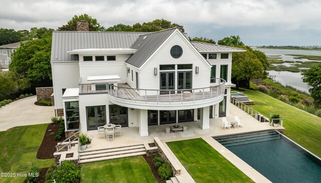 1064 Ocean Ridge Dr, Wilmington, NC 28405 - back of property with a balcony, a standing seam roof, a patio, a chimney, and a water view
