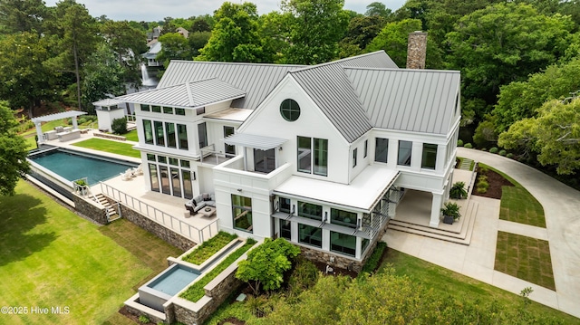 1064 Ocean Ridge Dr, Wilmington, NC 28405 - rear view of property with a standing seam roof, an outdoor pool, metal roof, a chimney, and a yard