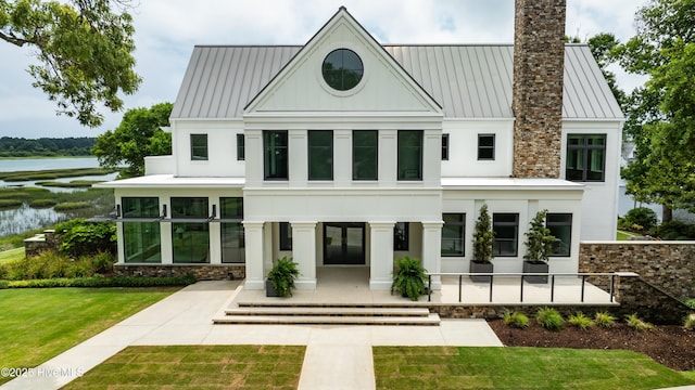 1064 Ocean Ridge Dr, Wilmington, NC 28405 - back of property with a standing seam roof, stucco siding, a chimney, and a water view