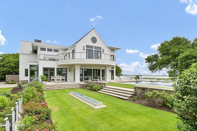 1064 Ocean Ridge Dr, Wilmington, NC 28405 - rear view of house featuring a balcony, a patio area, a yard, and a chimney