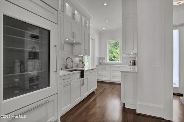 1064 Ocean Ridge Dr, Wilmington, NC 28405 - kitchen with dark wood-type flooring, light countertops, decorative backsplash, a sink, and white cabinetry