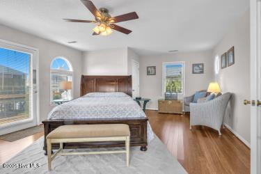 6707 Kings Lynn Dr, Oak Island, NC 28465 - bedroom featuring wood finished floors, a ceiling fan, and access to outside