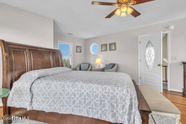 6707 Kings Lynn Dr, Oak Island, NC 28465 - bedroom featuring wood finished floors and ceiling fan