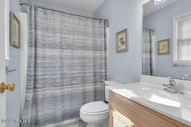 6707 Kings Lynn Dr, Oak Island, NC 28465 - bathroom with vanity, toilet, and a shower with shower curtain