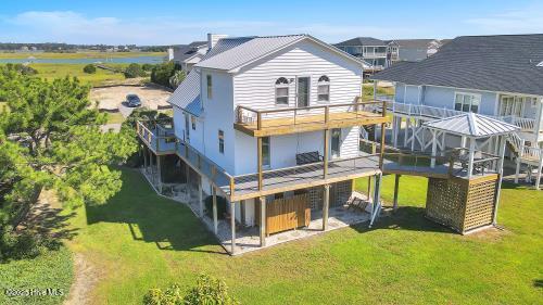 6707 Kings Lynn Dr, Oak Island, NC 28465 - back of house with a yard and a wooden deck