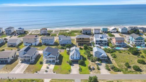 6707 Kings Lynn Dr, Oak Island, NC 28465 - aerial perspective of suburban area with a large body of water