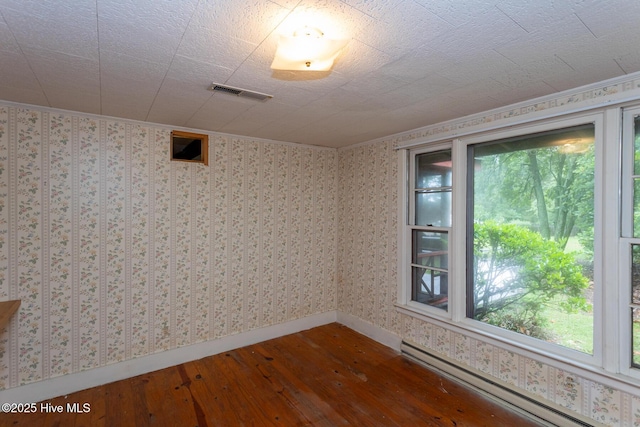 1772 NC-5 Hwy, Aberdeen, NC 28315 - unfurnished room featuring a baseboard radiator, dark wood-type flooring, baseboards, ornamental molding, and wallpapered walls