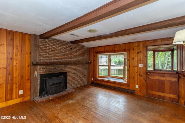 1772 NC-5 Hwy, Aberdeen, NC 28315 - unfurnished living room featuring baseboard heating, hardwood / wood-style floors, wood walls, beam ceiling, and a fireplace