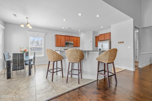 100 Little Acorn Trl, Moyock, NC 27958 - kitchen featuring stainless steel appliances, recessed lighting, baseboards, light wood-style flooring, and a kitchen breakfast bar